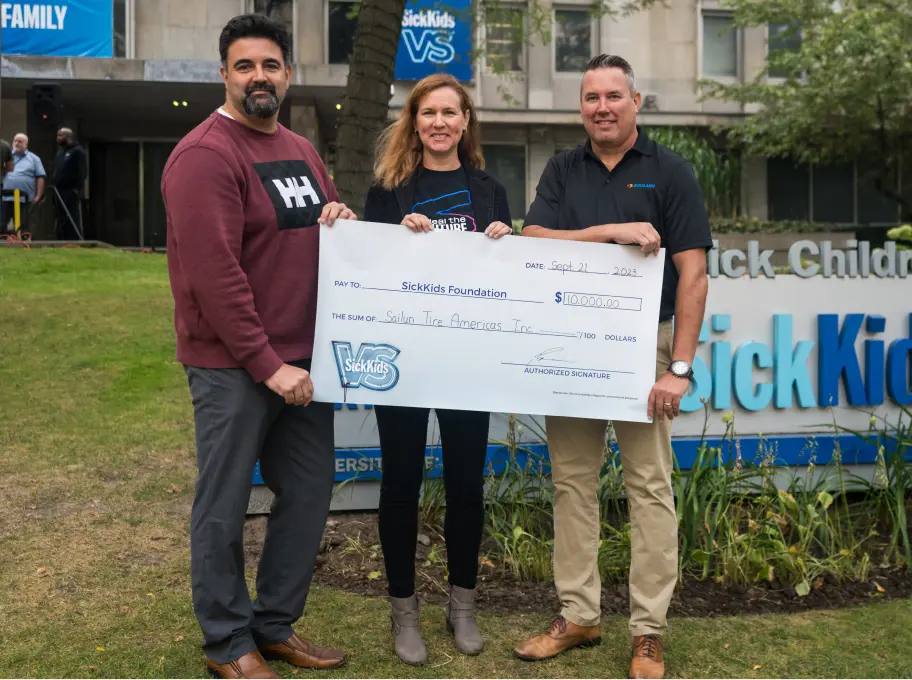 Representatives presenting a donation cheque in support of SickKids during a fundraising initiative to help achieve the organization’s donation goal.