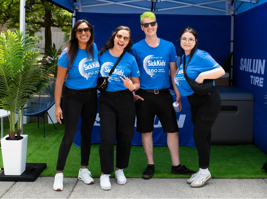 Group of volunteers wearing SickKids 150 Years Strong shirts during the SickKids anniversary celebration focused on care, research, and innovation.
